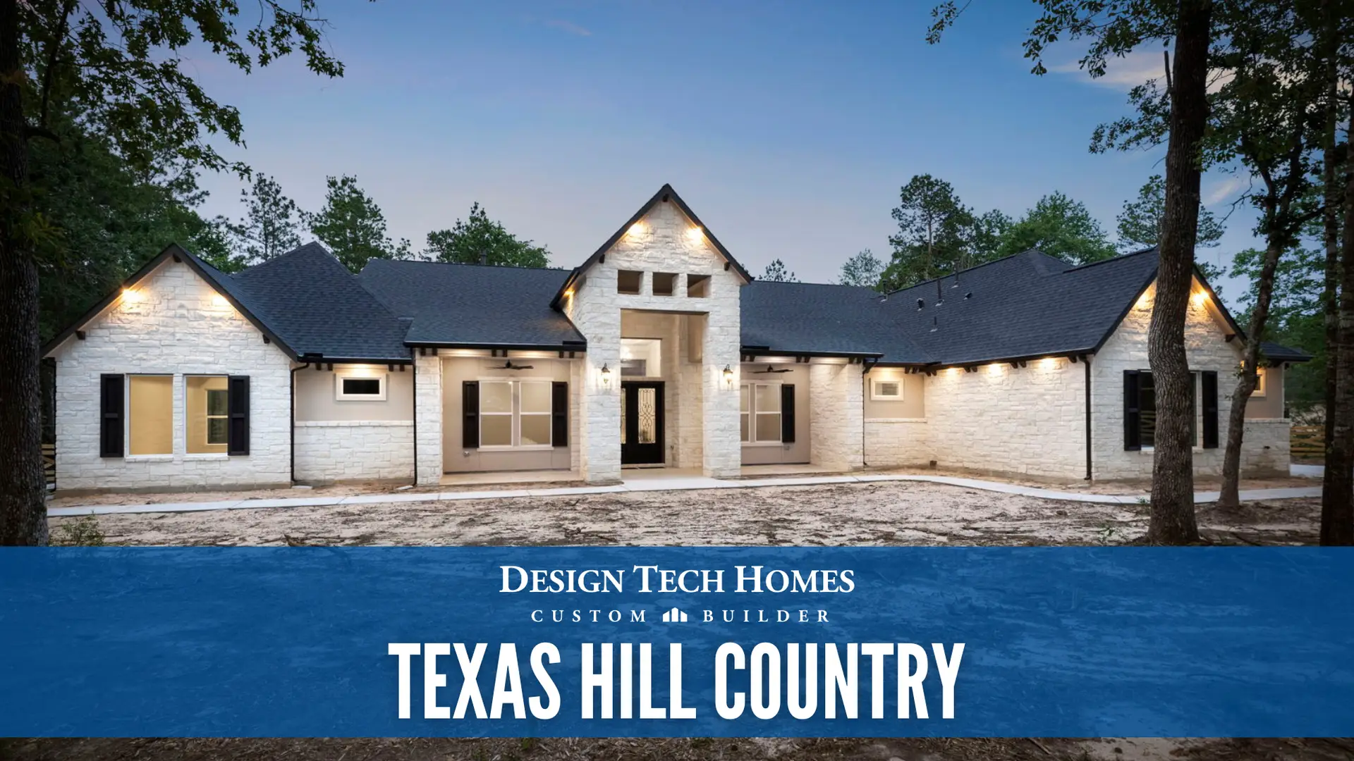 Texas Hill Country custom home with white stone exterior, large covered entry, black shutters, and metal roof at dusk among oak trees