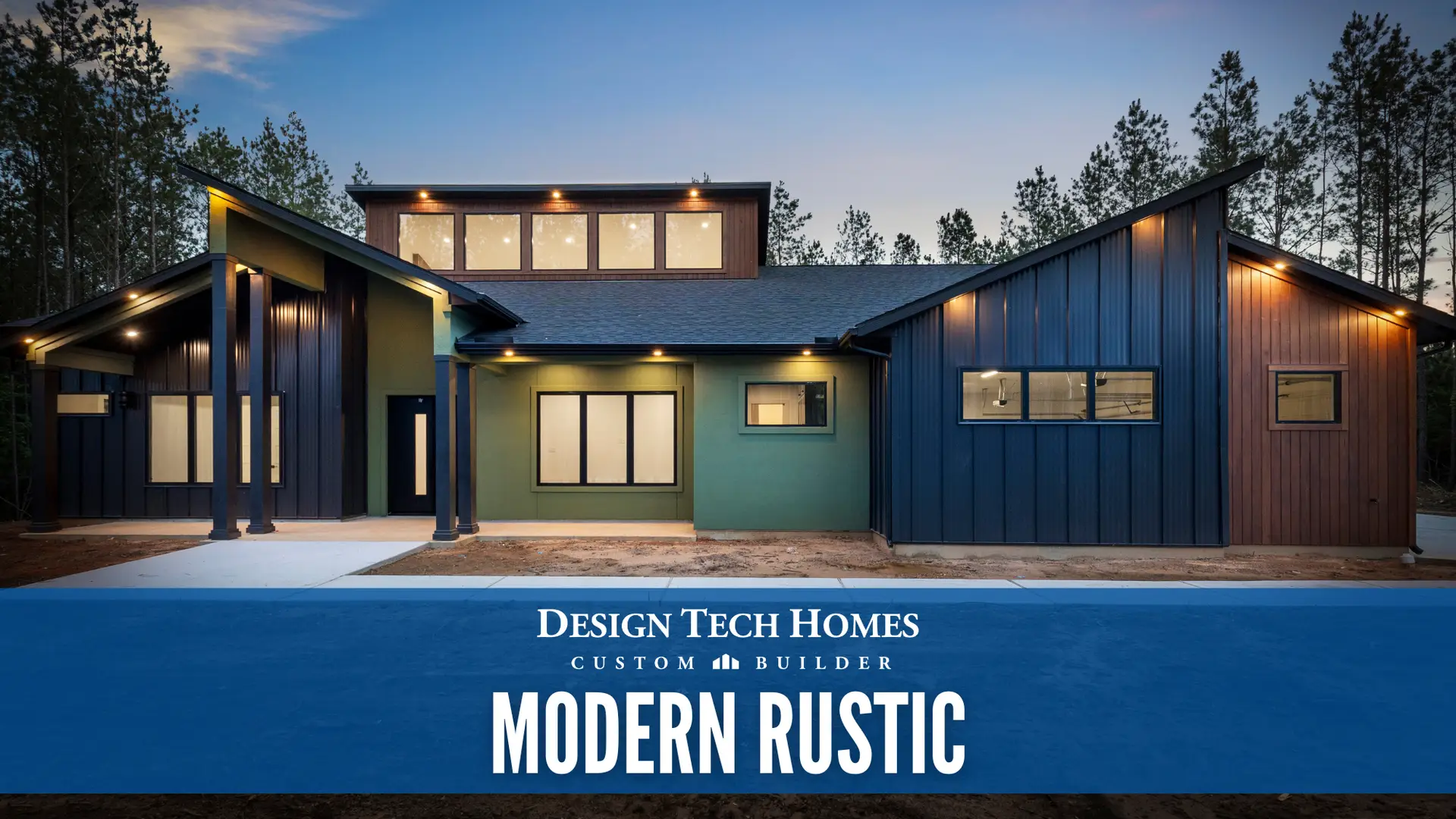 Modern rustic custom home exterior with mixed dark metal siding, wood panels, green stucco accents, large windows, and covered porch at dusk among pine trees