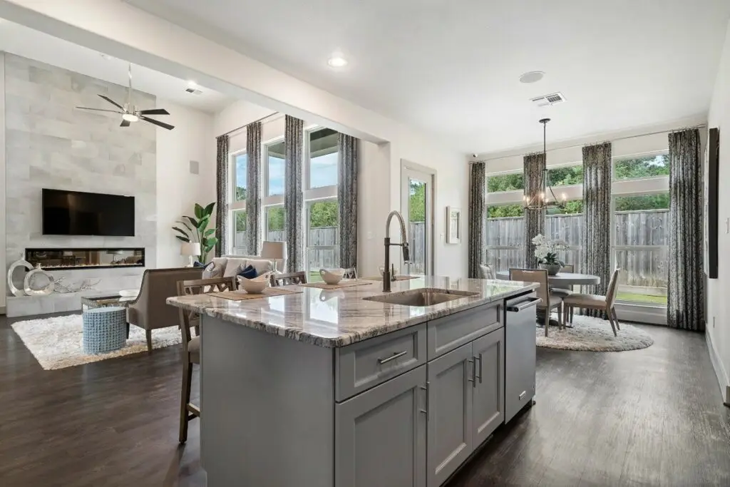 Open-concept kitchen and living area with large island, dining space, and floor-to-ceiling windows