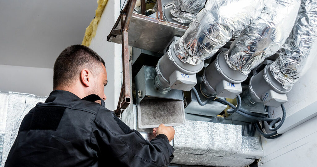 HVAC technician inspecting residential ventilation ductwork and air distribution system