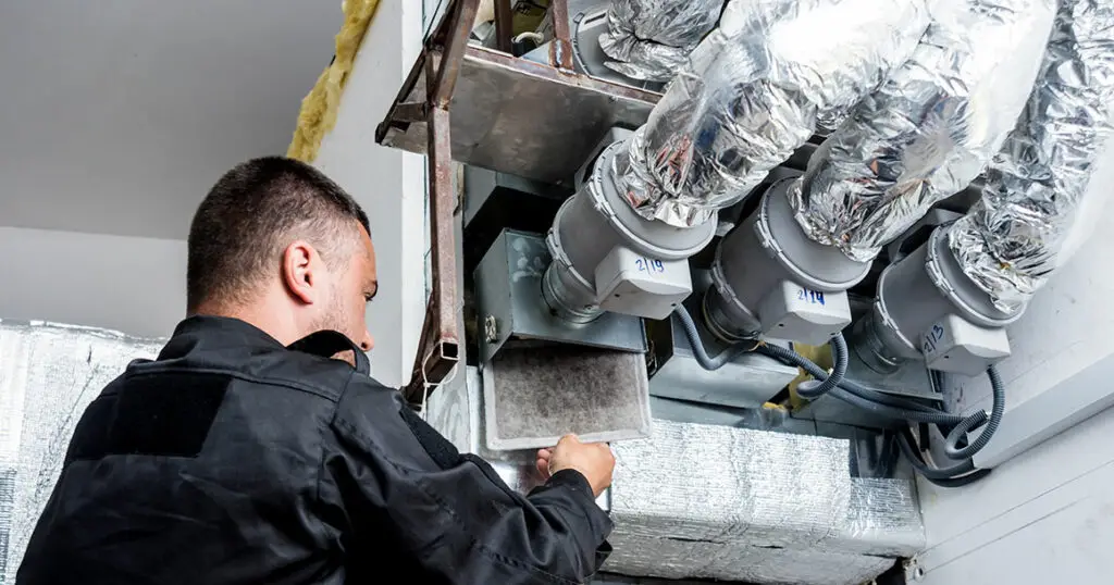 HVAC technician inspecting residential ventilation ductwork and air distribution system