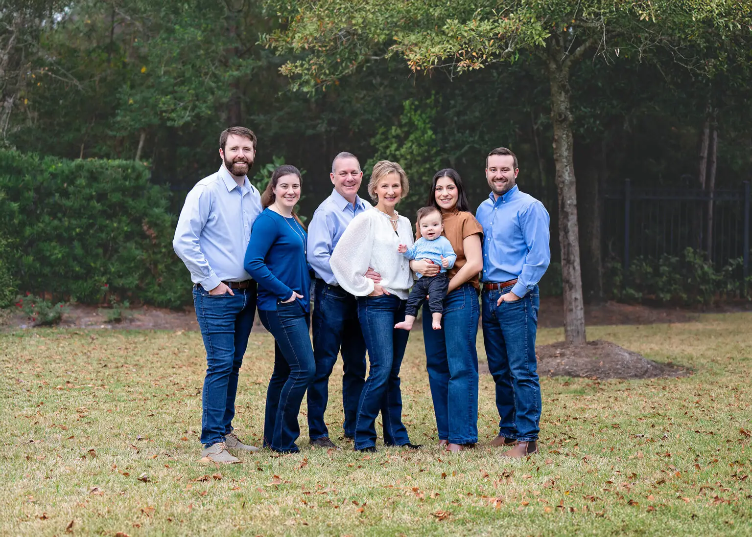 The Feigin family, owners of Design Tech Homes, standing together outdoors in a natural setting.