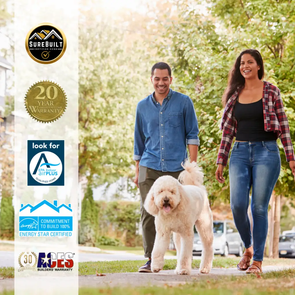 Couple walking their dog through a residential neighborhood with home certification badges displayed.