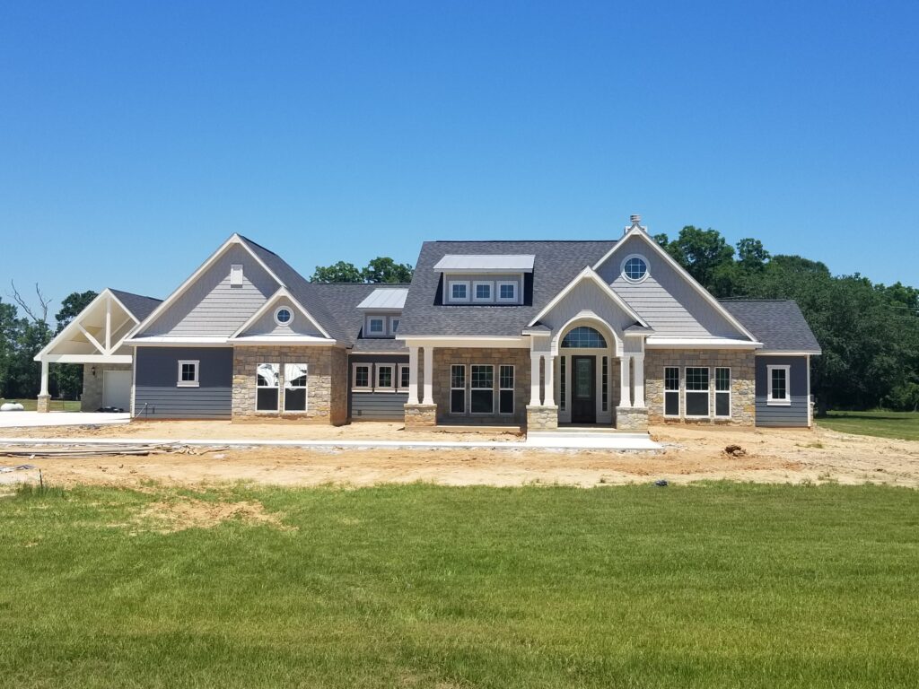 Custom coastal-style luxury home with stone and siding exterior built by Design Tech Homes in Houston