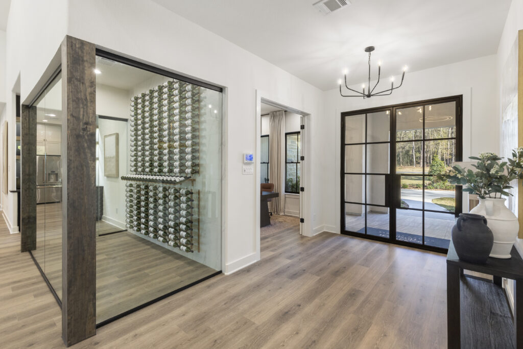 Glass-enclosed wine room in Design Tech Homes model home at The Estates of Texas Grand Ranch.