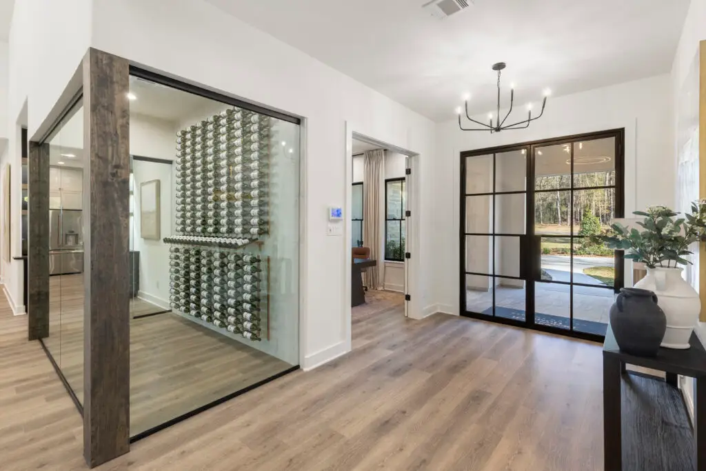 Glass-enclosed wine room in Design Tech Homes model home at The Estates of Texas Grand Ranch.
